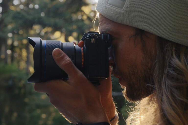 Fotógrafo usando el objetivo Laowa 12mm f/2.8 Lite Zero-D FF montado en una cámara mirrorless Sony durante una sesión en exteriores al atardecer