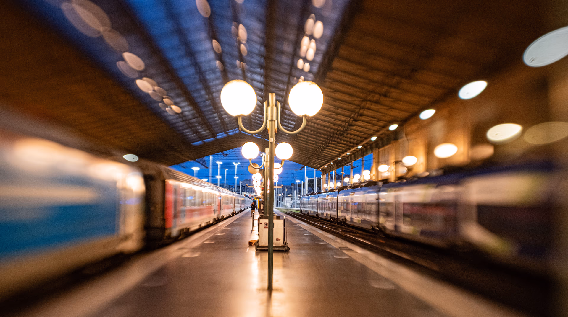 Andén vacío con trenes y farola al atardecer en París, fotografiado con la Fujifilm X100V