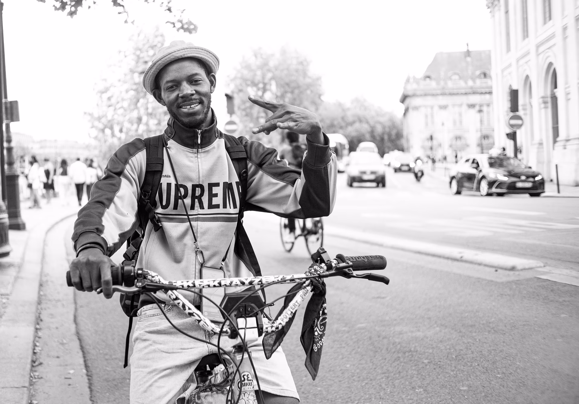 Hombre con bicicleta en una calle de París, fotografía en blanco y negro — street photography con Fujifilm X100V