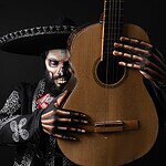 Hombre con maquillaje de Catrina y sombrero sostiene una guitarra, inspirado en las Catrinas del canal