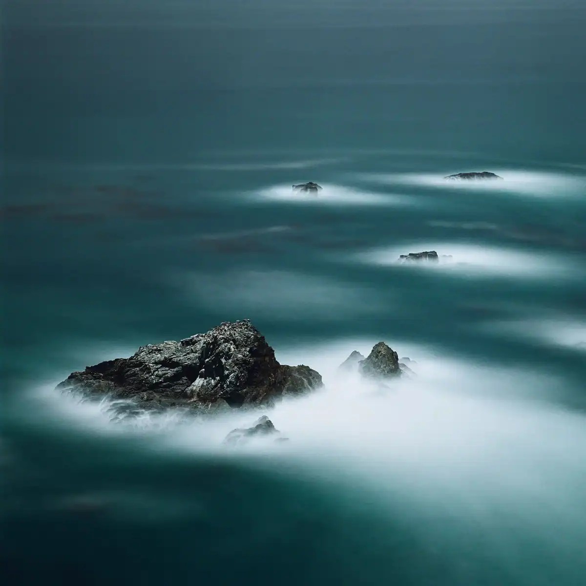 Fotografía de larga exposición de formaciones rocosas en el mar bajo la luz de la luna llena