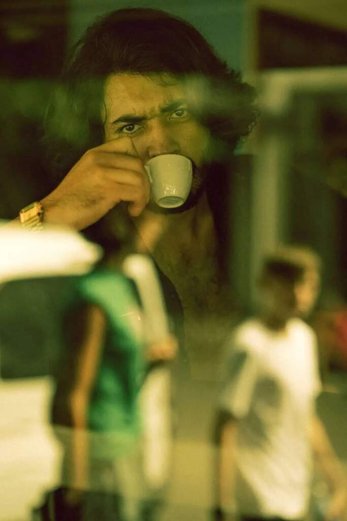 Hombre con filtro México en el cine bebiendo café, imagen distorsionada.