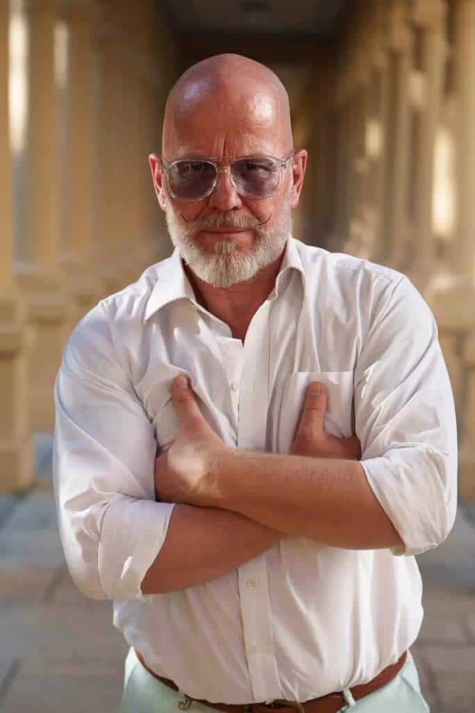 Hombre calvo con gafas y bigote, brazos cruzados, camisa blanca, representa el filtro México en el cine.