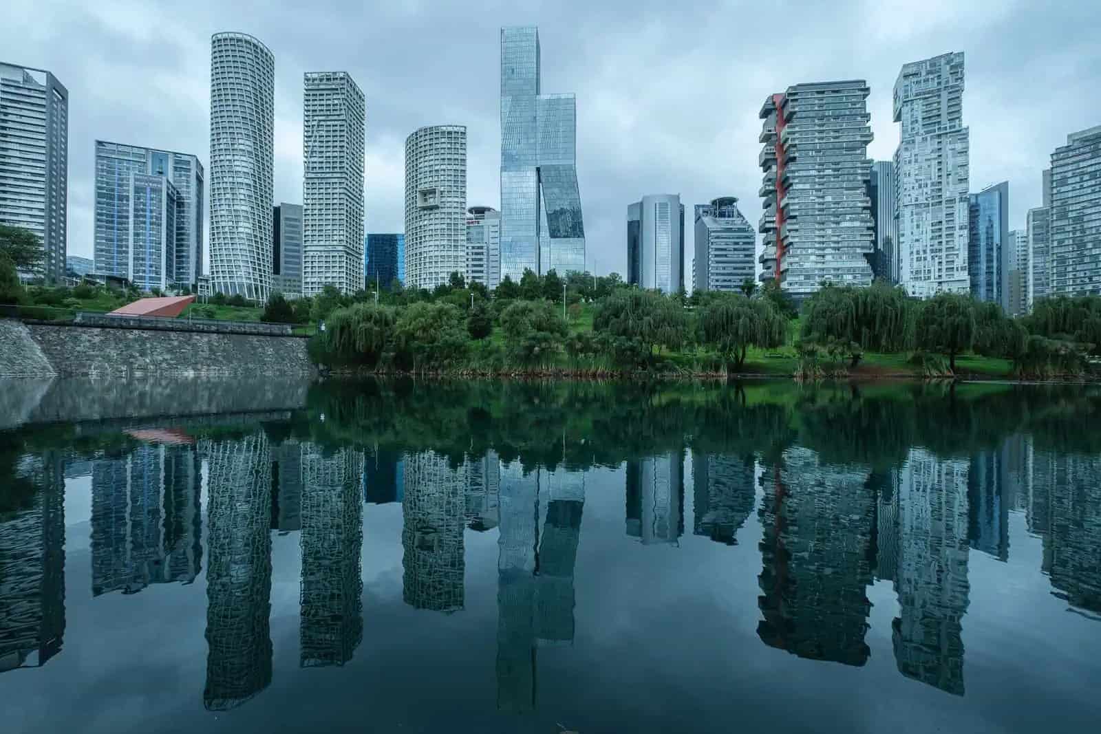 Edificios modernos reflejados en un lago, evocando el filtro México en el cine.