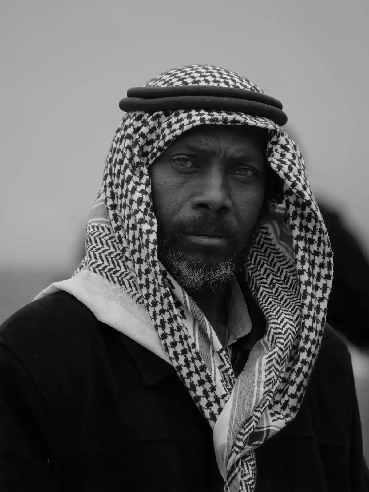 Retrato de un hombre con keffiyeh y barba, de mirada seria