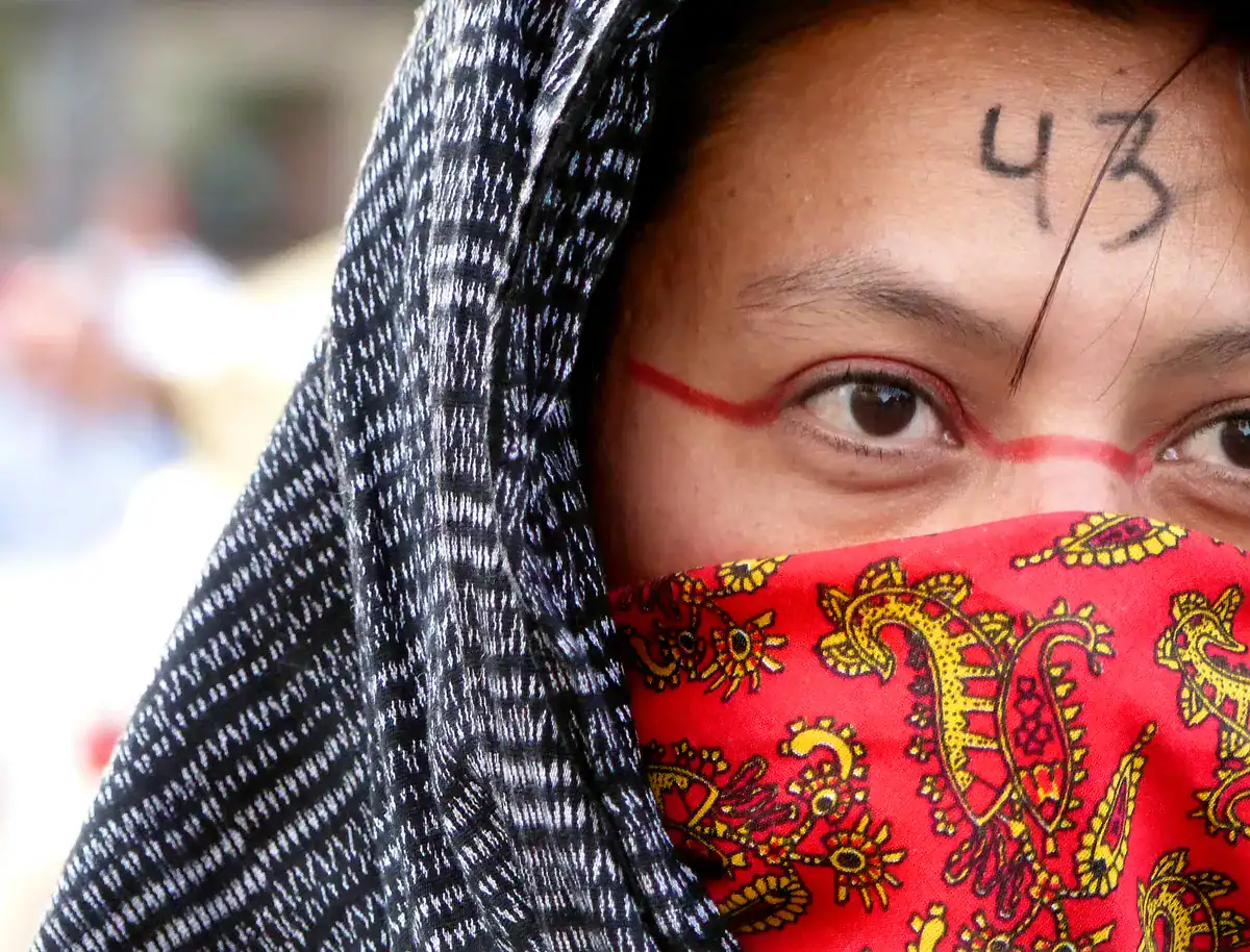 Primer plano de los ojos de una persona con el número "43" en la frente, cubiertos por un paño rojo, como en la obra de Jacob Prado.
