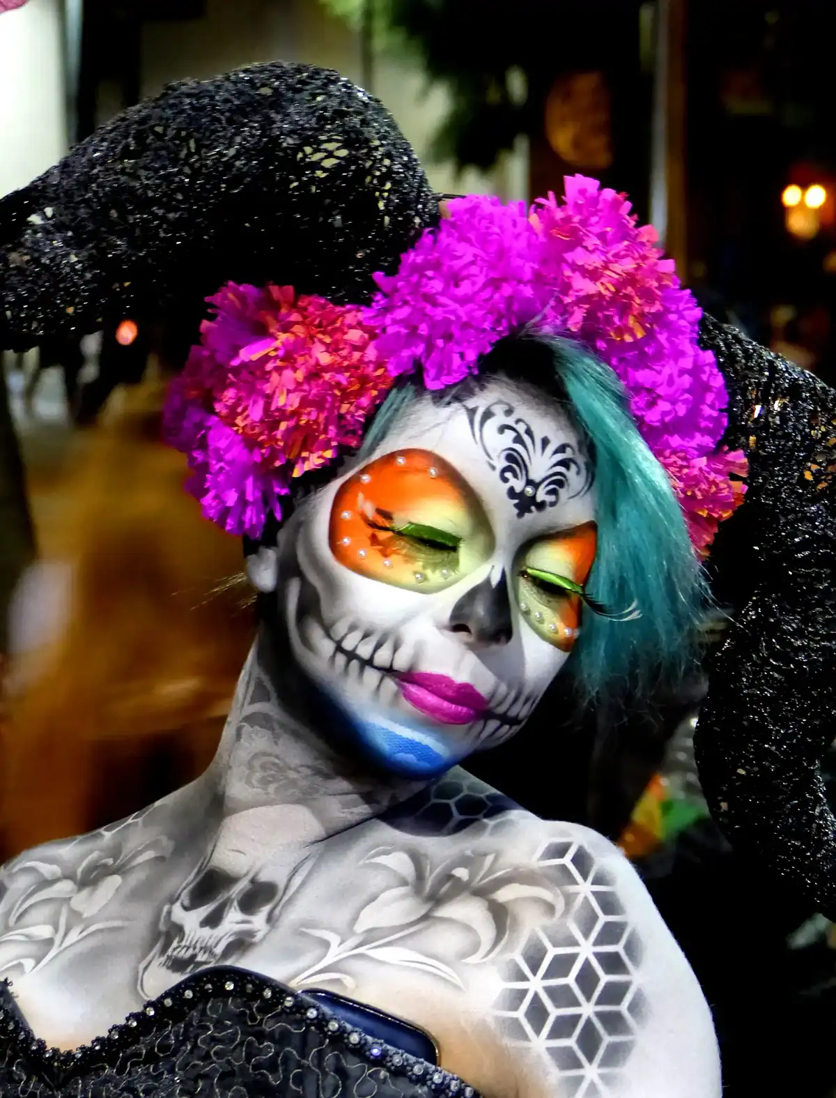 Mujer con maquillaje de calavera, corona de flores y elaboradas pinturas corporales