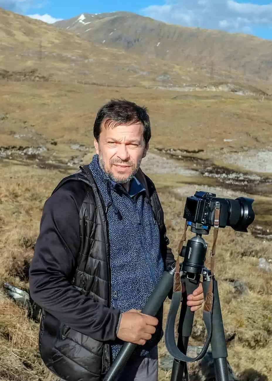 Fotógrafo Stefan Mayr con cámara en trípode en paisaje montañoso, fotografía como forma de omitir.