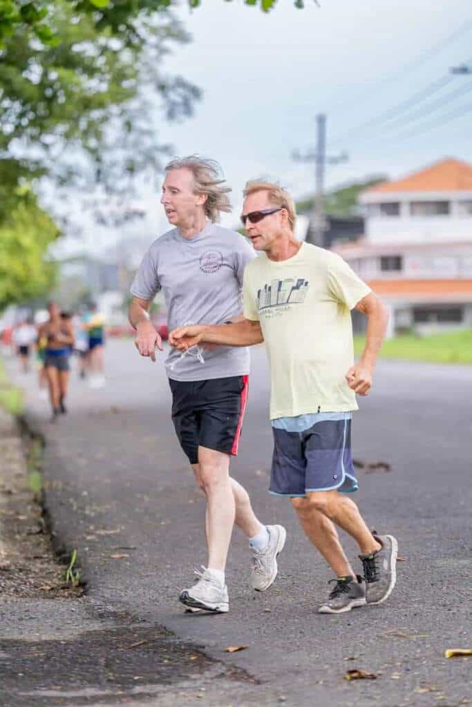 Dos corredores mayores disfrutan de una carrera matutina, arte y deporte combinados.