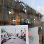 Reflejo de cámaras antiguas en escaparate, anticipando los precios de cámaras y accesorios en 2026.